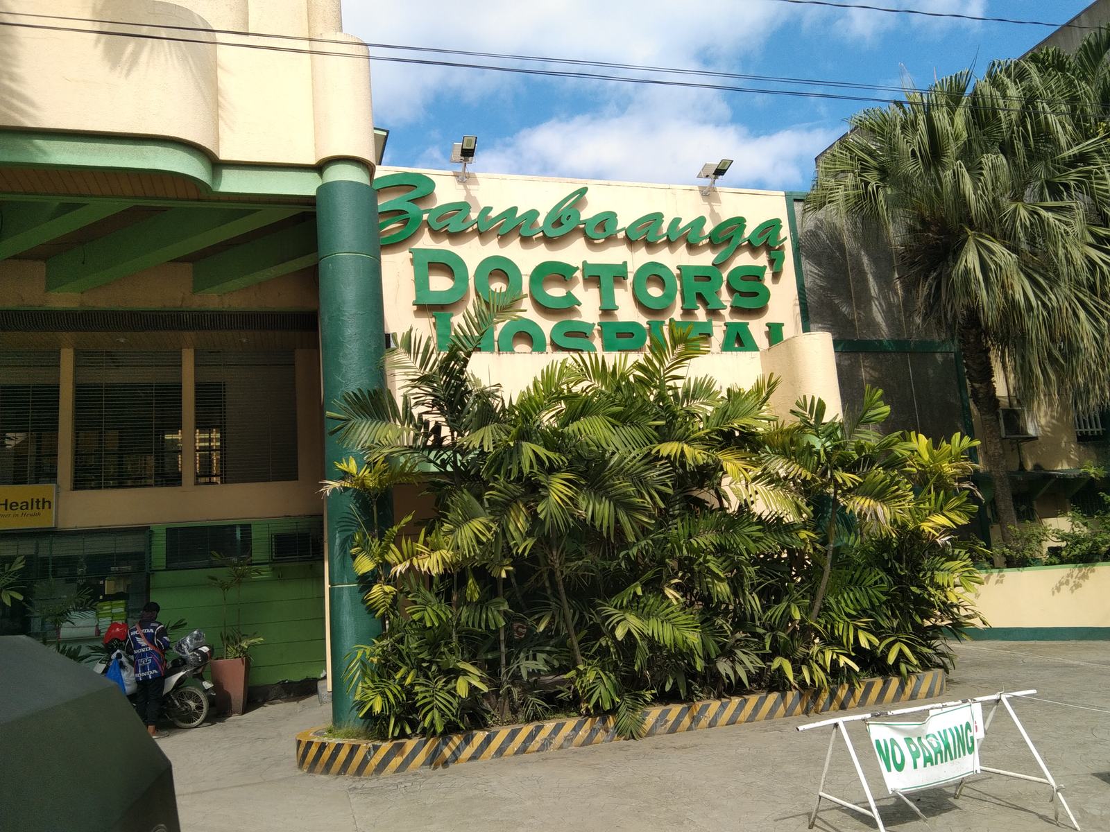 The green Zamboanga Doctors Hospital lettering above the entrance, behind a bed of palms.